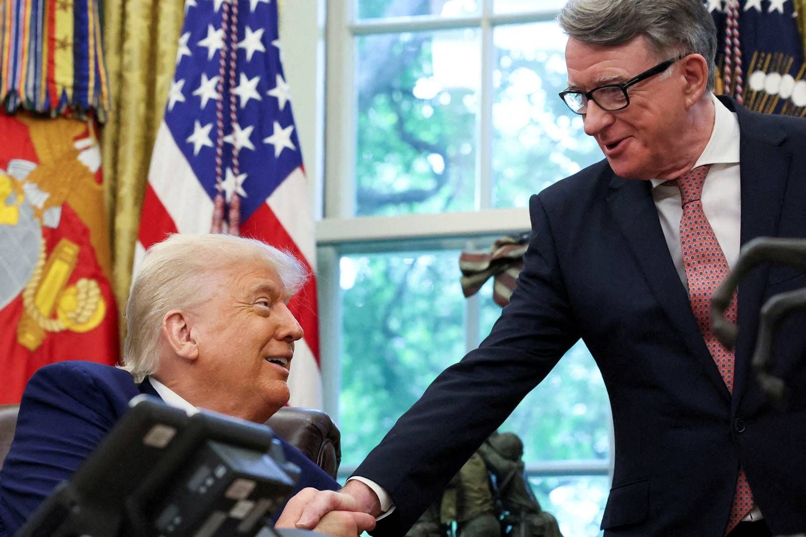 Donald Trump giver hånd til den britiske ambassadør Peter Mandelson efter at have annonceret en ny handelsaftale med Storbritannien 8. maj. | Foto: Leah Millis/Reuters/Ritzau Scanpix