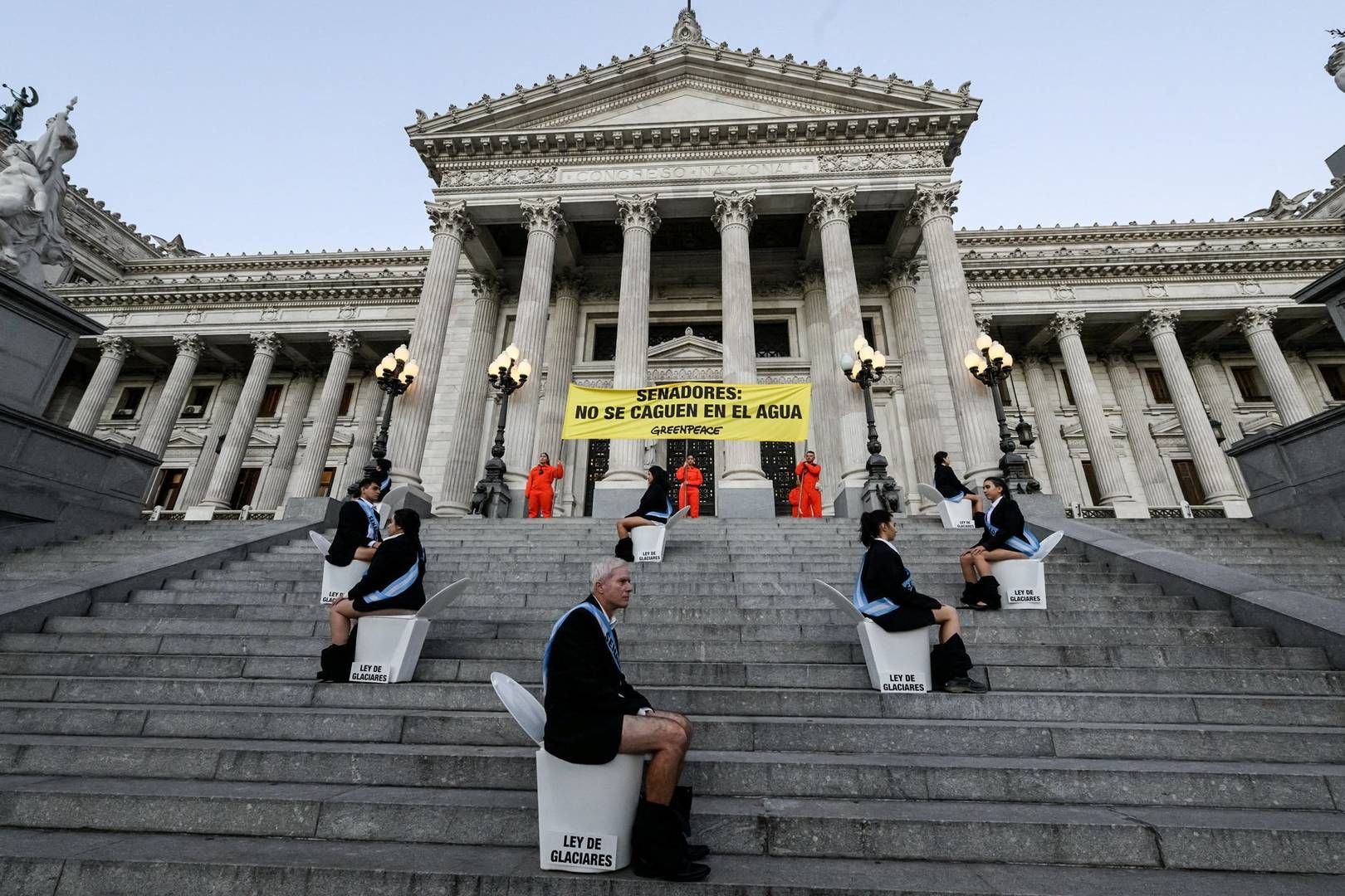 Billedet er fra en tidligere demonstration i Buenos Aires, Argentina torsdag. Her demonstrerede Greenpeace-aktivister siddende på toiletter, mens andre viste et banner med sloganet "Senatorer: lad være med at skide på vandet" under en protest mod ændringer i en lov om beskyttelse af gletsjere | Foto: Martin Katz/greenpeace Argentina